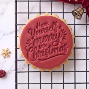 Have Yourself a Merry Little Christmas cookie stamp shown on a finished festive biscuit