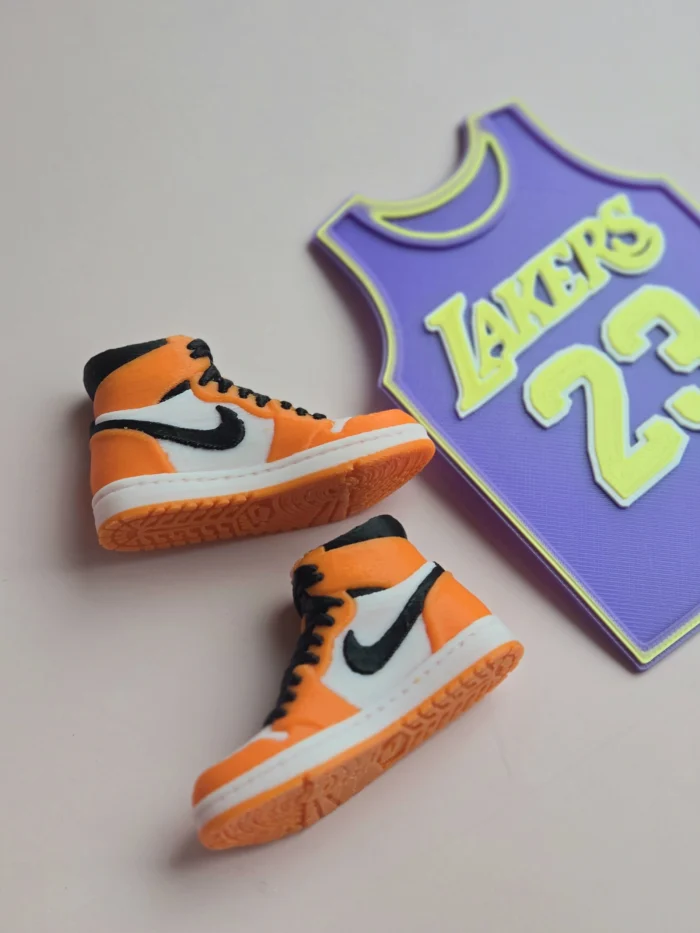 custom basketball jersey cake topper with name and number 23 and two orange high top sneaker cake toppers