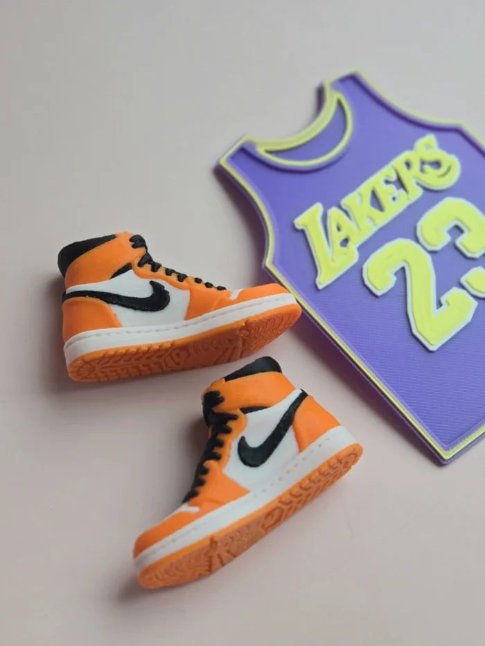 custom basketball jersey cake topper with name and number 23 and two orange high top sneaker cake toppers