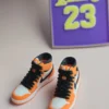 custom basketball jersey cake topper with name and number 23 and two orange high top sneaker cake toppers