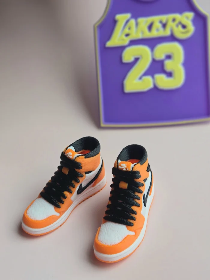 custom basketball jersey cake topper with name and number 23 and two orange high top sneaker cake toppers