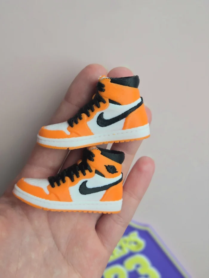 custom basketball jersey cake topper with name and number 23 and two orange high top sneaker cake toppers
