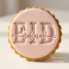 Pink fondant biscuit embossed with “Eid Mubarak” using a round scalloped cookie stamp