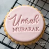 Round pink fondant biscuit embossed with the words “Umrah Mubarak” using a cookie stamp